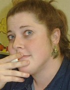 Kathy Silverman Red-haired woman holding a pen and looking pensive